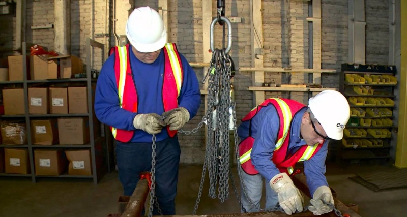 worker inspecting rigging equipment before use